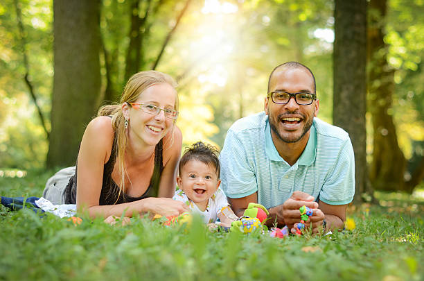 счастливая семья - adoption family multi ethnic group human teeth стоковые фото и изображения