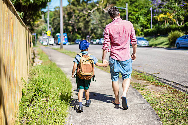 istock Father and son walking to school 498613194
