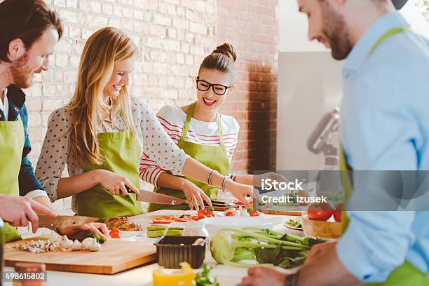 Foto de Quatro Pessoas Participar Na Aula De Culinária e mais fotos de stock de Aula de Culinária - Aula de Culinária, Cozinhar, Oficina de trabalho