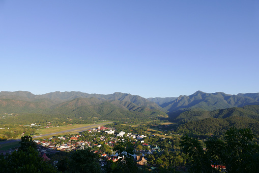view of Mae Hong Son city in northern Thailand in the evening with runway of airport and mountain background