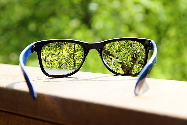 istock eyeglasses in the hand over blurred tree background 498616121