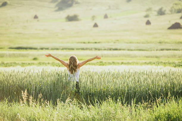 istock one young woman in wheat field expressing positivity 498616249