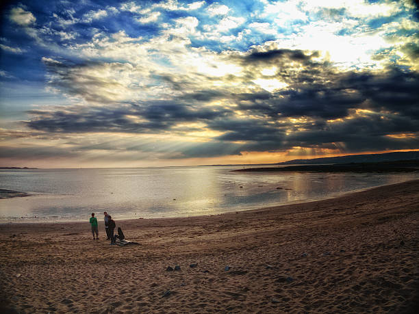 золотой свет приближаться закате - wales beach editorial people стоковые фото и изображения