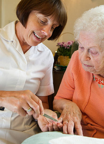 istock Care worker nurse caring for an elderly woman's nails 498617459