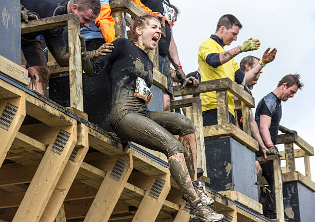 Boughton House, Northamptonshire, UK - May 4, 2013: Although terrified, this participant overcame fear--albeit with a little help from a team mate--to conquer the Tough Mudder obstacle 'Walk the Plank'.