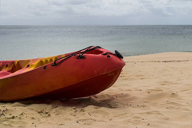 The kayak docks on a beach The red kayak docks on a beautiful beach beautiful multi colored tranquil scene enjoyment stock pictures, royalty-free photos & images