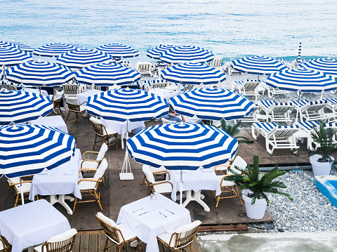 Blue umbrellas on a beach on the French Riviera in Nice, France.