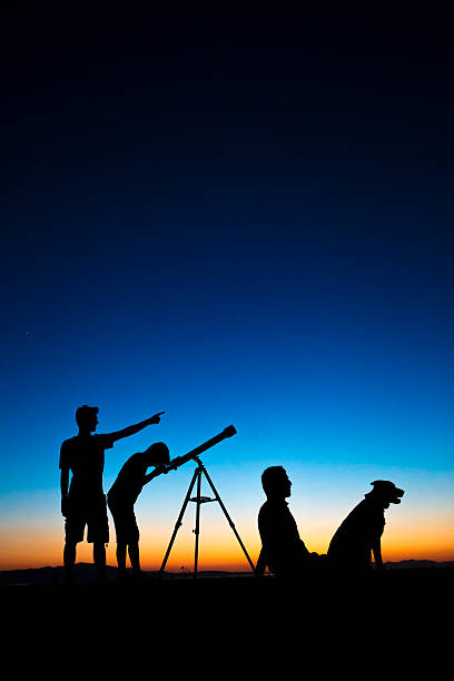 istock Dad and sons on a clear night looking thru telescope 498632367