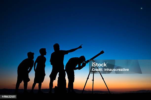 Dad And Three Sons Looking Thru A Telescope Stock Photo - Download Image Now - Astronomy, Child, Star - Space