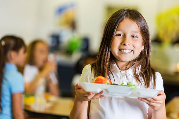 istock Cute elementary student holding lunch tray in school cafeteria 498632919
