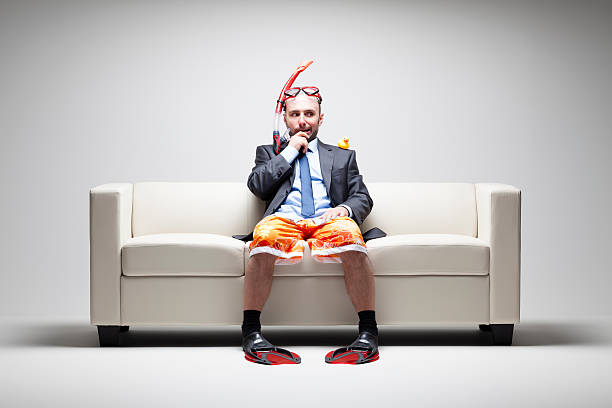istock Vacation desparately needed - Businessman Couch Snorkel Swim suit 498633549