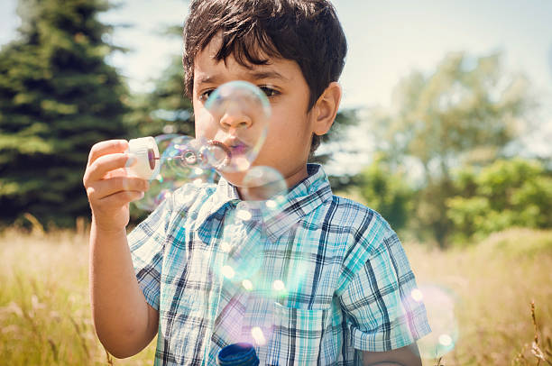 istock Cute little boy blowing bubbles outdoors 498634027