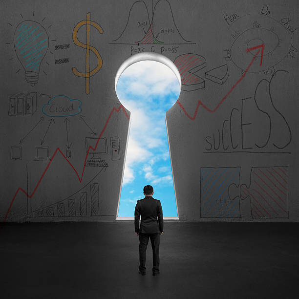 istock Businessman facing key shape door with blue sky outside 498634379