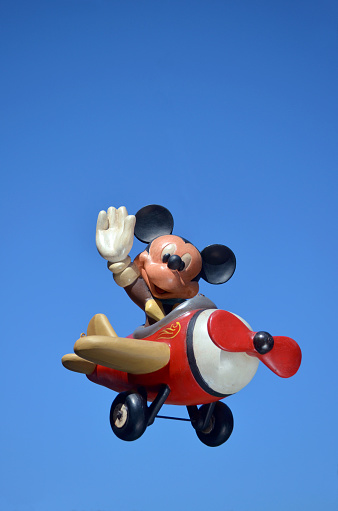 Monchique, Faro - Portugal, 17, April 2013. Studio image of a Mickey Mouse resin figure with a sky background.  Mickey is flying his plane while waving to his fans. Mickey is part of a huge private collection of resin big figs that were sold in selective stores around the world.  Mickey mouse was created by Walt Disney in 1928 Photo taken April 17th, 2013