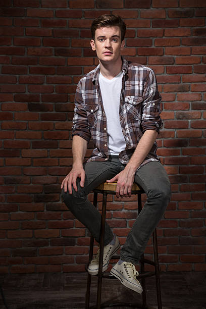 istock Confident young guy sitting on bar chair 498648470