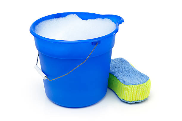 Cleaning Bucket and Sponge Blue bucket with soapy water and a sponge. Isolated on white. bucket and sponge stock pictures, royalty-free photos & images