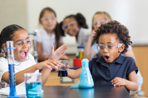 Excited students doing chemistry experiement in science class at school