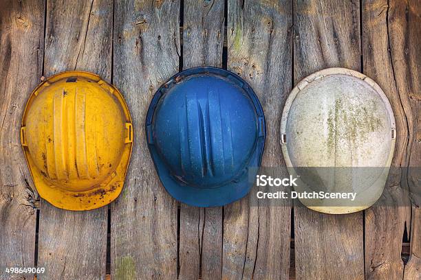 Drei Vintagekonstruktion Helme Auf Eine Hölzerne Mauer Stockfoto und mehr Bilder von Bauarbeiterhelm