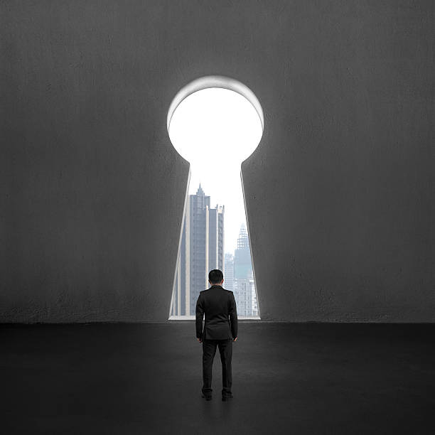 istock Standing in front of key shape hole with city view 498651057