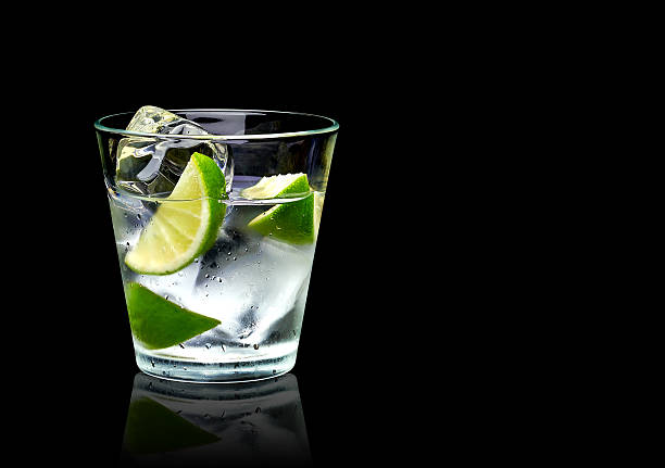 Vodka with lime and ice Vodka lime with ice in rocks glass on black background including clipping path tonic water stock pictures, royalty-free photos & images