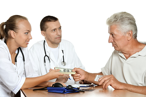 Elderly male patient giving money to doctors