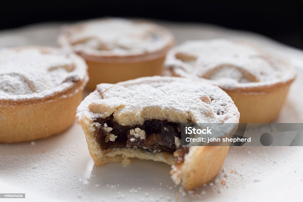 Mince Pies Plate of Mince Pies, front one has a bite taken out. Mince Pie Stock Photo