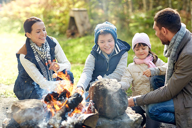 istock happy family roasting marshmallow over campfire 498658004