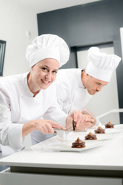 istock cheerful young woman professional pastry cook at work 498659574