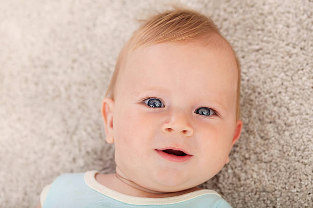 istock Happy baby boy lying down on the carpet 498659650