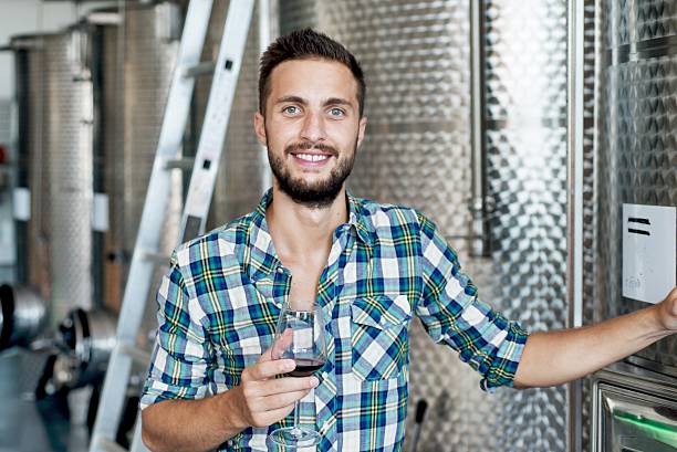 Smiling Man in Modern Winary Smiling Man in Modern Winary wine producer stock pictures, royalty-free photos & images