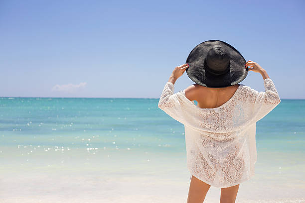 istock Woman in summer hat on the beach 498660080