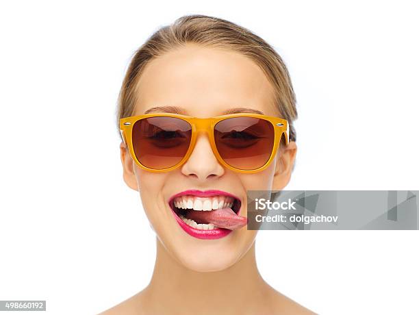 Feliz Mujer Joven Con Gafas De Sol Que Muestra La Lengua Foto de stock y más banco de imágenes de Gafas de sol
