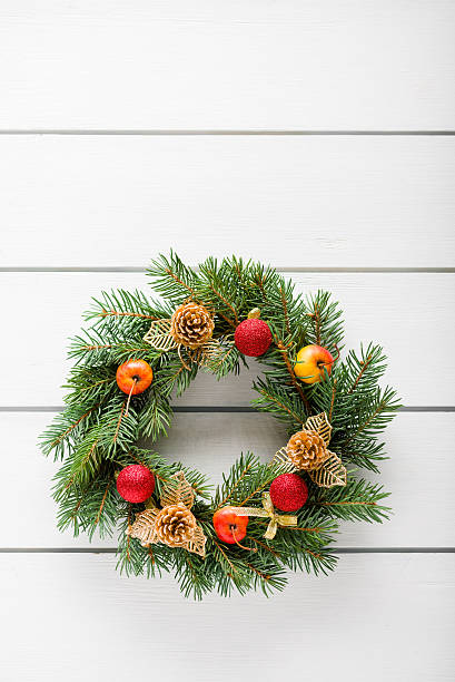 istock Christmas wreath on white wooden table top view 498661456