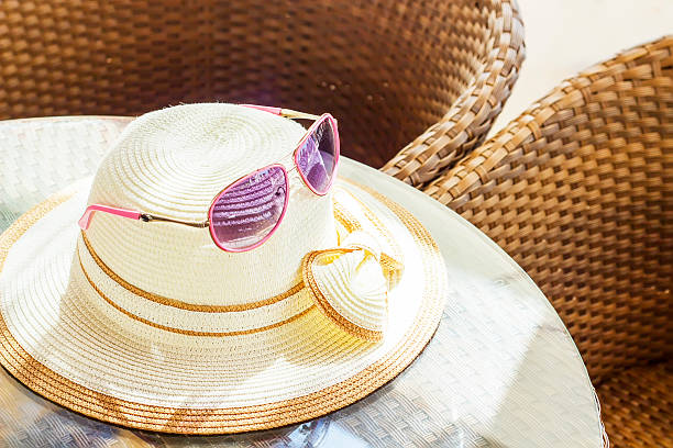 istock Hat with a bow and sunglasses on a table 498663496