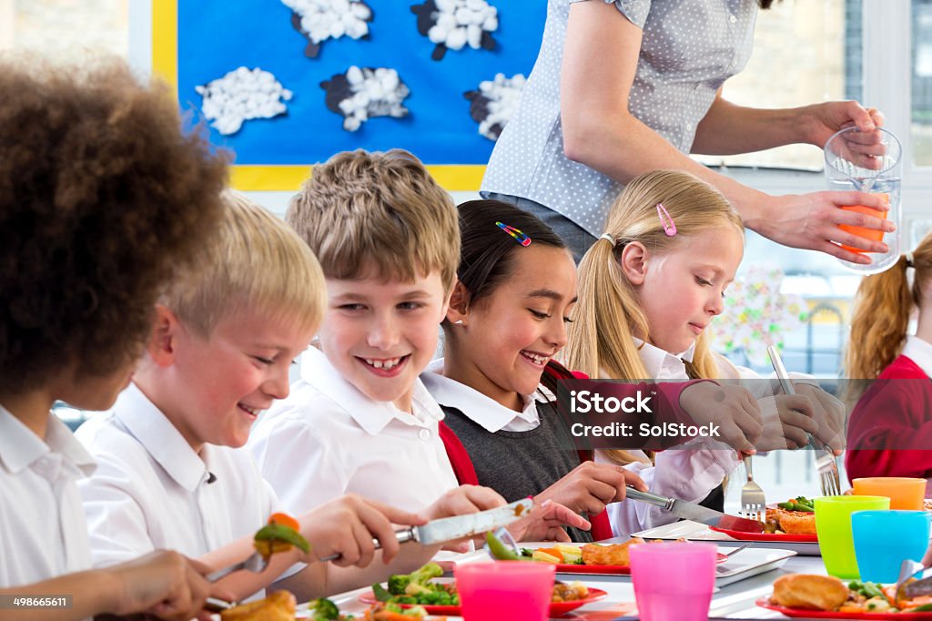 Children Eating School Dinners Happy school children enjoying their school dinners Cafeteria Stock Photo