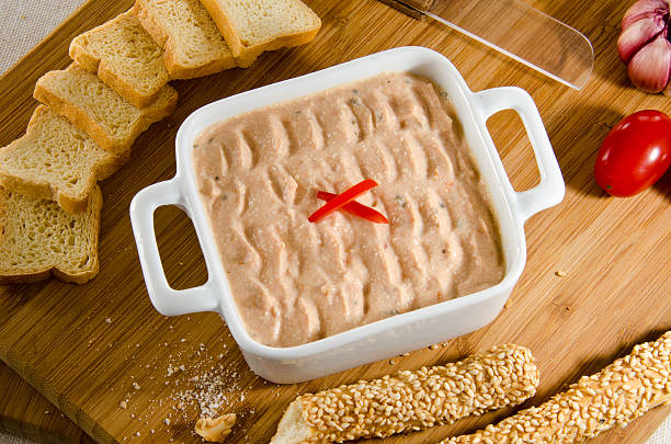 Italian antipasto Italian antipasto on a white china, garlic, cherry tomato, sesame breadsticks, mini-toasts, plastic knife, wooden cutting board. Italian antipasto in a white porcelain, garlic, cherry tomatoes, sesame sticks, mini-toast, tomato knife, wood cutting table. comida italiana stock pictures, royalty-free photos & images