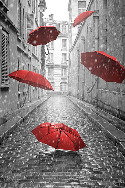 istock Red umbrellas flying on the street. Conceptual image 498665979