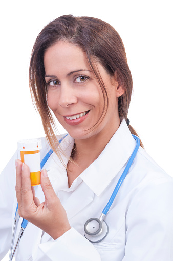 Portrait of pretty hispanic female doctor in lab coat smiling as she holds amber medicine bottle with white label and text space on white background