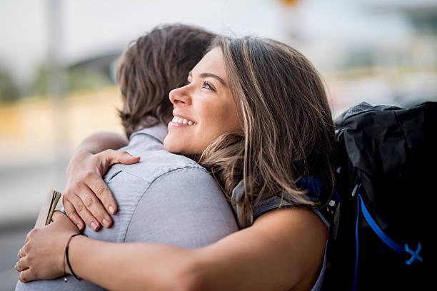 Woman saying goodbye Traveling woman saying goodbye at the airport airport hug stock pictures, royalty-free photos & images