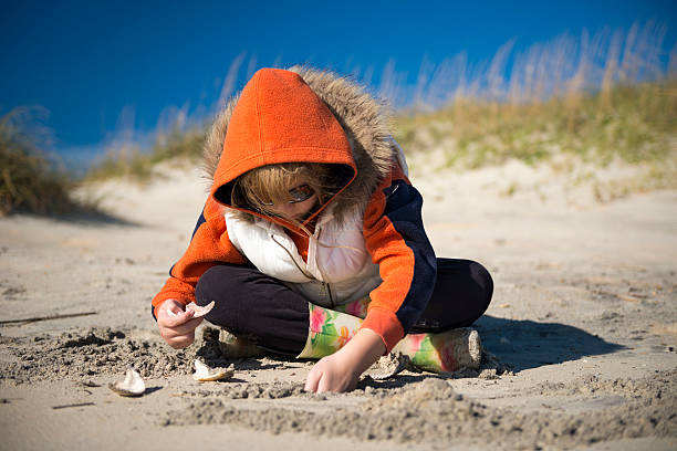 Young girl playing in the sand stock photo