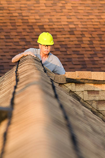 istock Home inspector examines architectural, asphalt shingled roof. 498681821