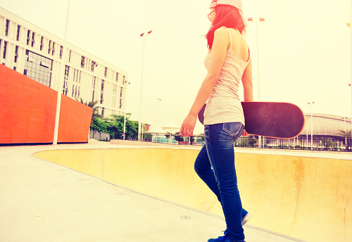 woman skateboarder walking at skatepark
