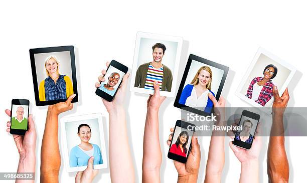 Hands Holding Digital Devices With Peoples Images Stock Photo - Download Image Now - African Ethnicity, Asian and Indian Ethnicities, Casual Clothing