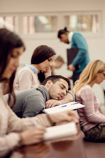 młody mężczyzna student do spania w klasie - student sleeping boredom college student zdjęcia i obrazy z banku zdjęć