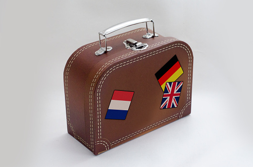 Travel Suitcase with flag stickers, Isolated on white.