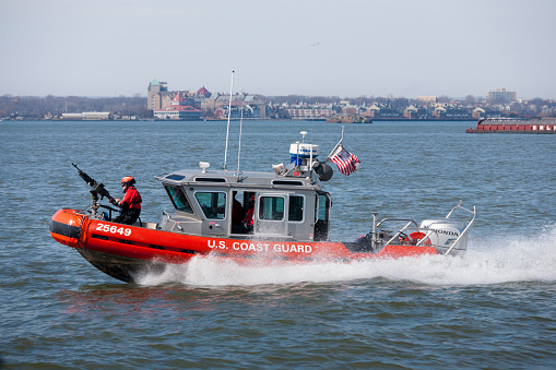 New York, March 8, 2014 – US Coast Guard boat patrolled NY harbor near Statue of Liberty.