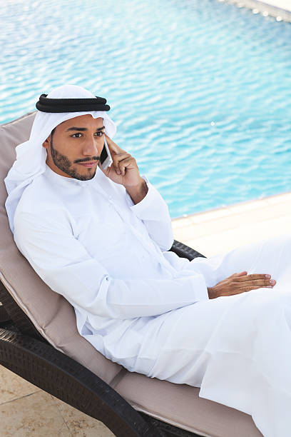 istock Middle Eastern Man on the Phone by the Swimming Pool 498691604