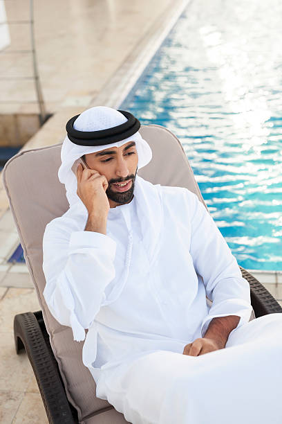 istock Muslim Man Talking on Phone on a Beach Chair 498691962