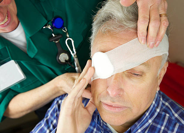 Paramedic nurse attending to a patient's eye after injury stock photo