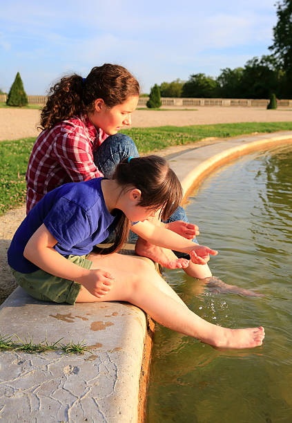 istock Young girls playing with fountain 498693896